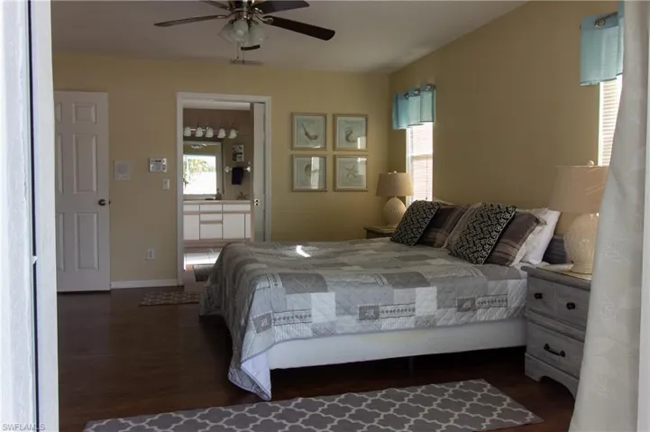 Bedroom featuring dark wood-type flooring, ceiling fan, and multiple windows