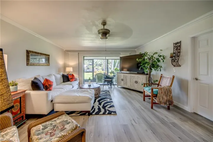 Living room featuring ceiling fan, crown molding, and hardwood / wood-style flooring