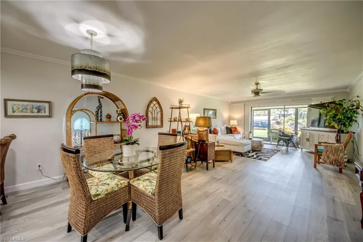 Dining area featuring light hardwood / wood-style floors, crown molding, and ceiling fan