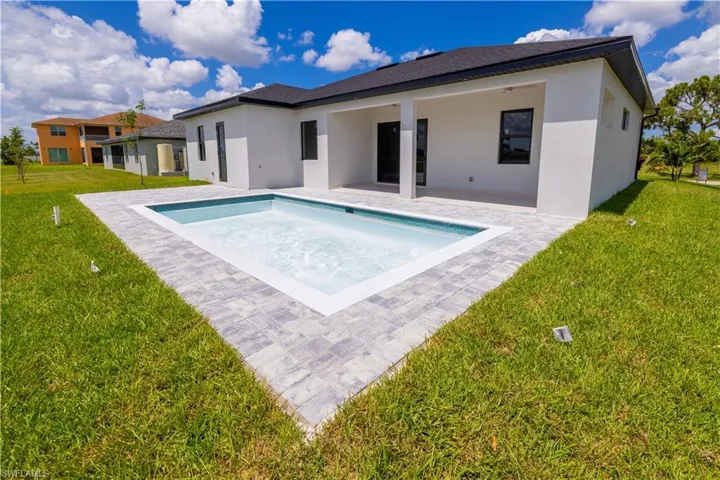 View of pool featuring a lawn and a patio