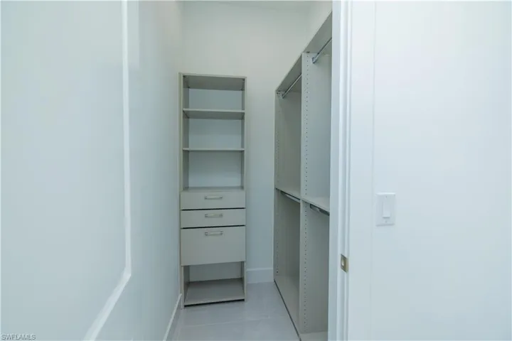 Spacious closet featuring light tile floors