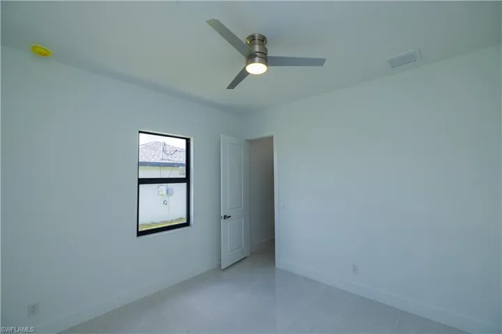 Spare room featuring ceiling fan and light tile flooring