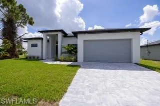 View of front of home with a front lawn and a garage