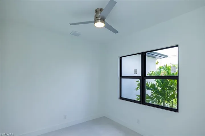 Spare room with a healthy amount of sunlight, tile flooring, and ceiling fan