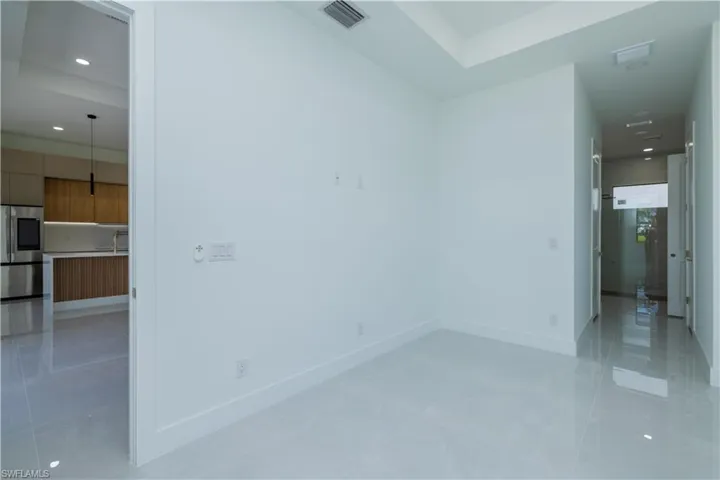 Spare room featuring a tray ceiling and light tile floors