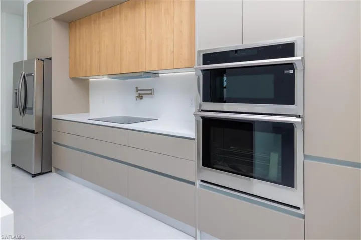 Kitchen with white cabinetry, light tile flooring, and stainless steel appliances