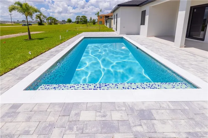 View of swimming pool featuring a patio area and a yard