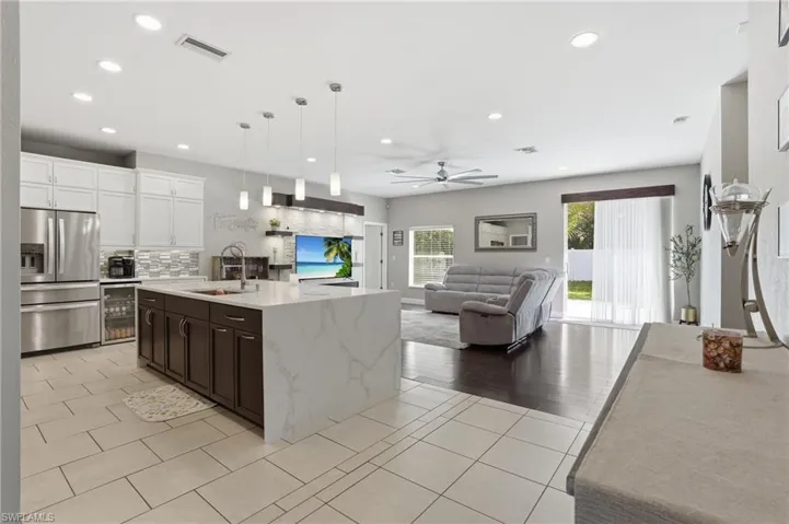 Contemporary kitchen with waterfall island, tile backsplash, and extensive cabinetry