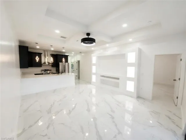 Unfurnished living room with coffered ceiling and recessed lighting