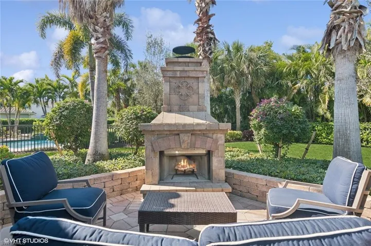 Open air extended patio surrounded by lush green privacy bushes, fenced yard