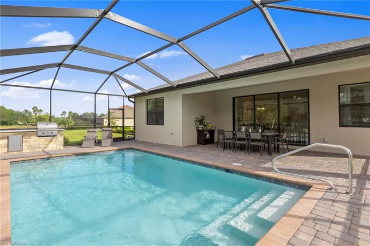 Screened pool enclosure with an integrated swimming pool and paver deck
