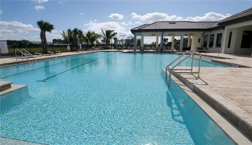 Expansive outdoor swimming pool with integrated lane lines and stainless steel handrails