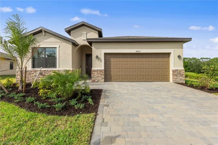 Stucco exterior featuring stacked stone accents, a two-car garage with a panel door, and an arched entry