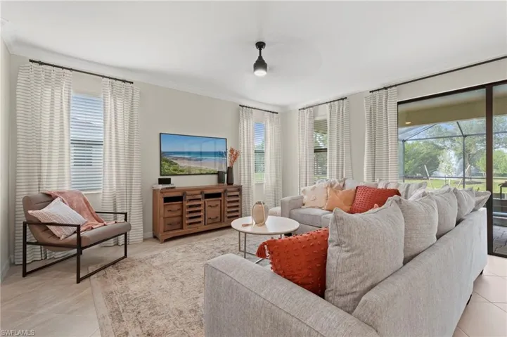 Spacious living area featuring light-colored wall paint and crown molding