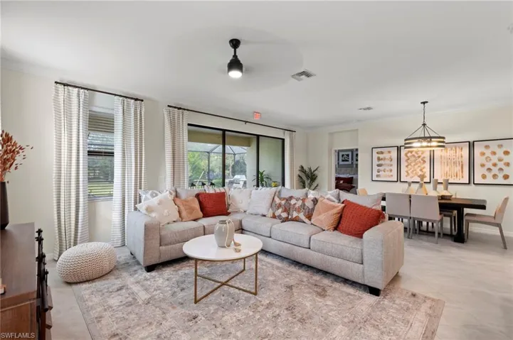 Spacious living area featuring light-toned flooring, crown molding, and recessed lighting