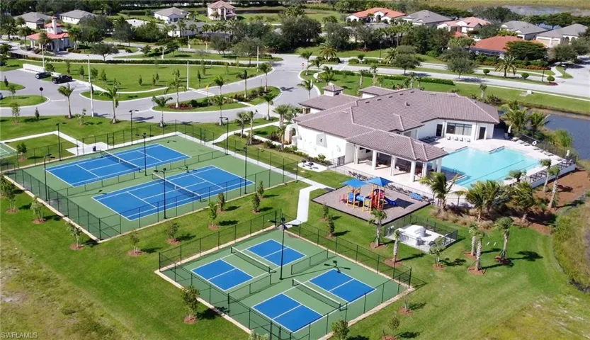 Community clubhouse featuring a large swimming pool, covered patio, and multiple sports courts