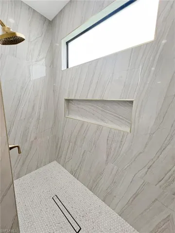 Bathroom featuring a marble finish shower