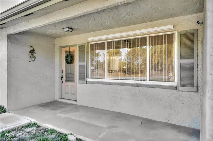 Entrance to property featuring stucco siding and covered porch