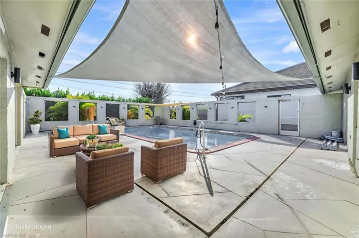 Virtually Staged View of swimming pool featuring a patio area and an outdoor hangout area