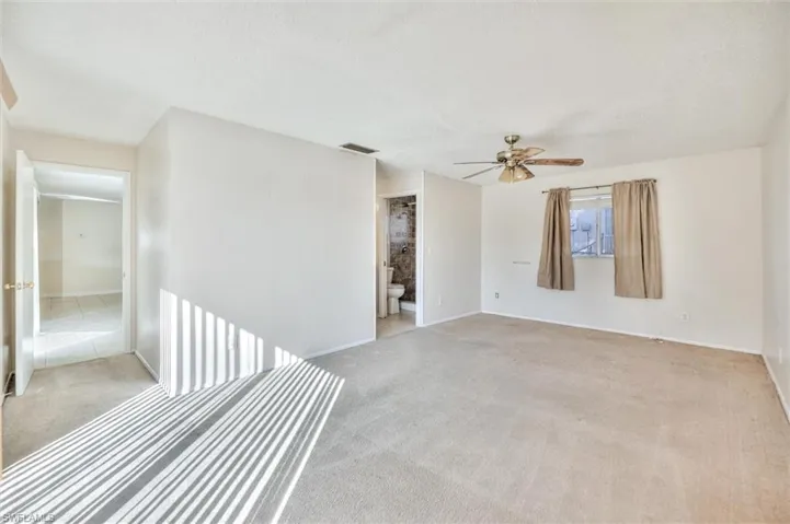 Carpeted spare room featuring a ceiling fan and a textured ceiling