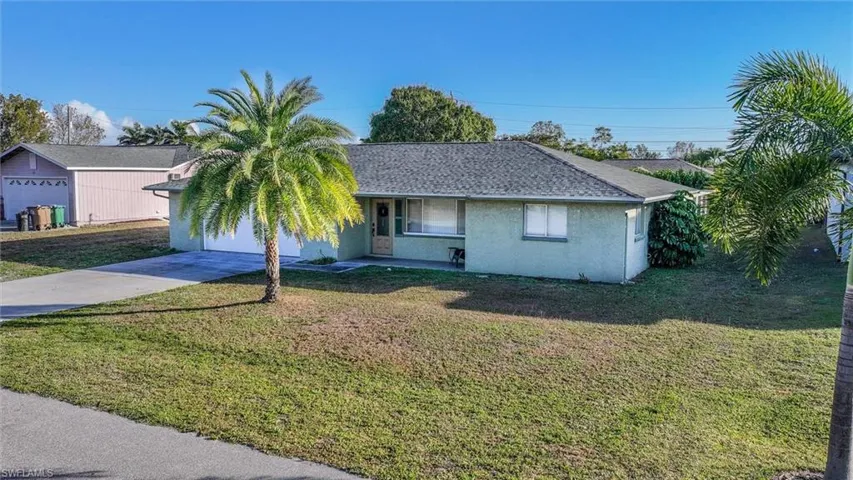Ranch-style house with stucco siding, a front lawn, and covered porch