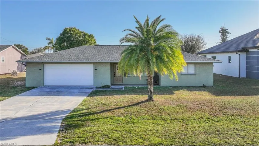 View of front of house featuring stucco siding, driveway, and roof with shingles