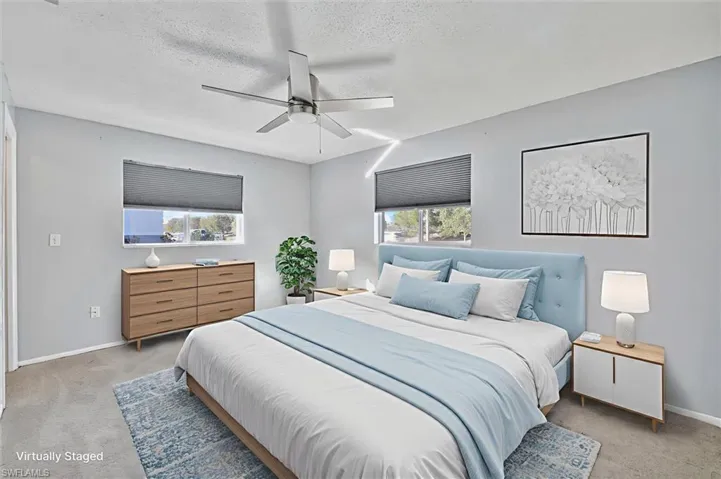 Virtually Staged Carpeted bedroom with a ceiling fan and a textured ceiling