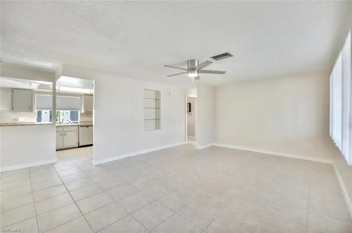 Spare room featuring a textured ceiling, a ceiling fan, and light tile patterned floors