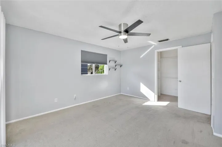Unfurnished bedroom featuring light colored carpet and ceiling fan