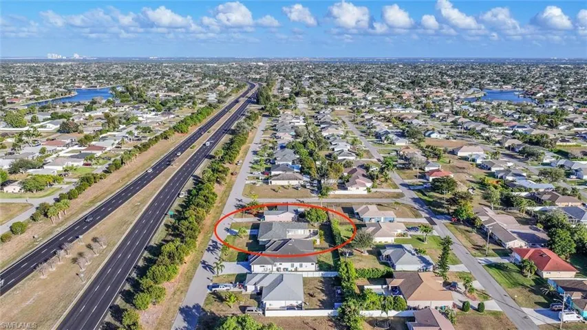 Aerial view of property's location featuring a nearby body of water and nearby suburban area