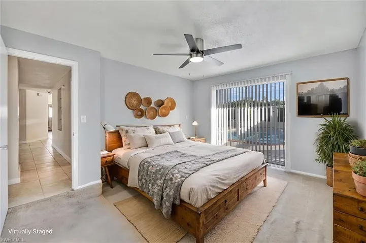 Virtually Staged Bedroom with light carpet, access to outside, ceiling fan.
