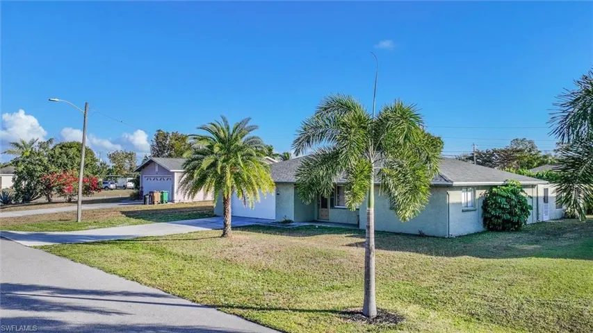 View of front of home featuring a front lawn, stucco siding, concrete driveway, and a shingled roof