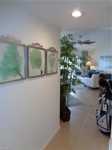 Hallway with tile patterned flooring and lofted ceiling