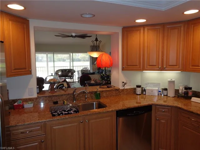 Kitchen with recessed lighting, dishwasher, ceiling fan, stone countertops, and brown cabinetry