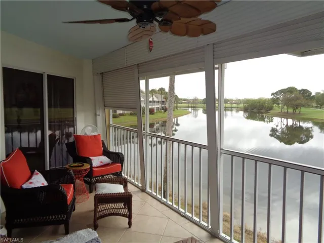 Sunroom with tile patterned floors and a water view