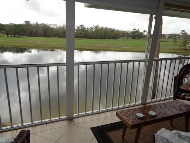 Balcony with a water view and view of wooded area