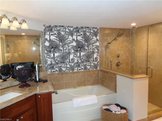 Full bath featuring a stall shower, vanity, a garden tub, and recessed lighting