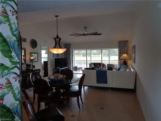 Dining room with vaulted ceiling, ceiling fan, and tile patterned flooring