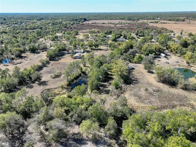 Aerial view of property and surrounding area with a nearby body of water