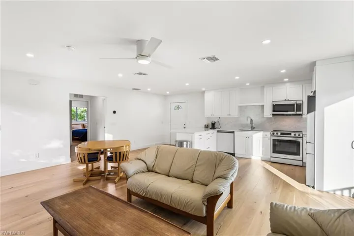 Living room featuring recessed lighting, ceiling fan, and light wood-type flooring