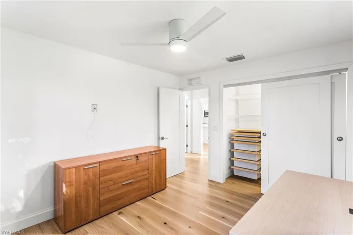 Office area featuring light wood-style floors and ceiling fan