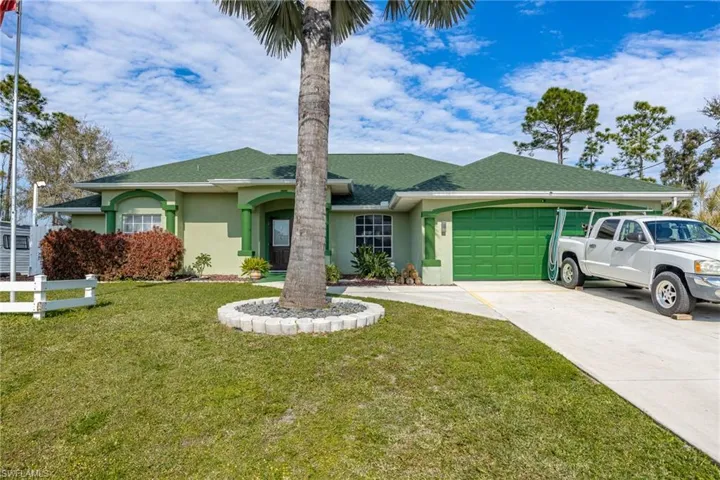 Single story home with a front yard and a garage