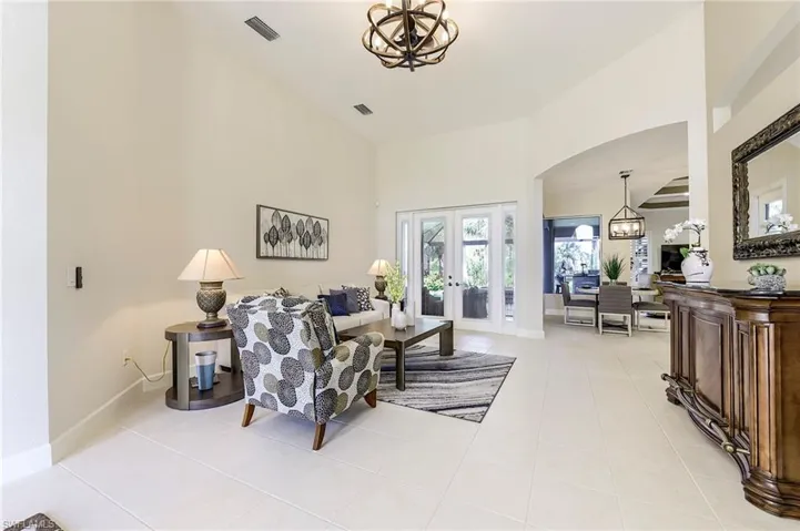 Dining area has a frameless corner window with a pool view
