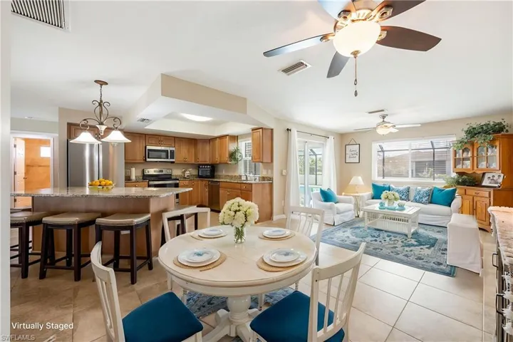 VIRTUALLY STAGED DINNING AND SITTING AREA Dining room with light tile patterned floors