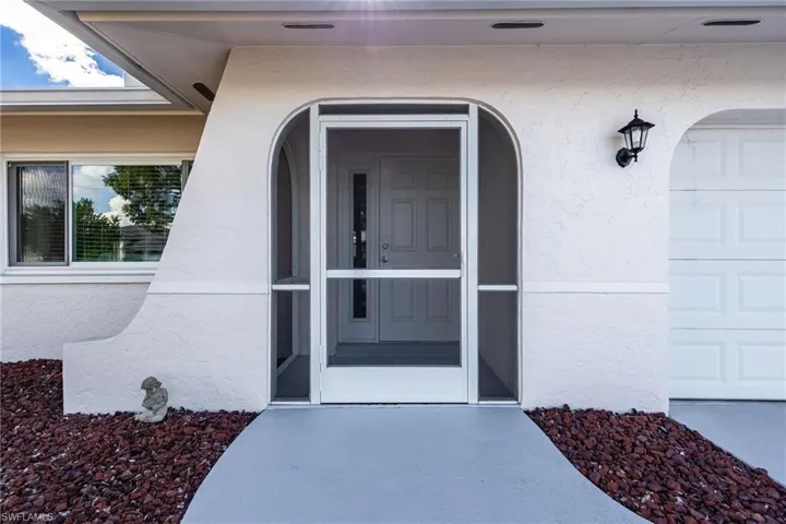 Doorway to property featuring stucco siding