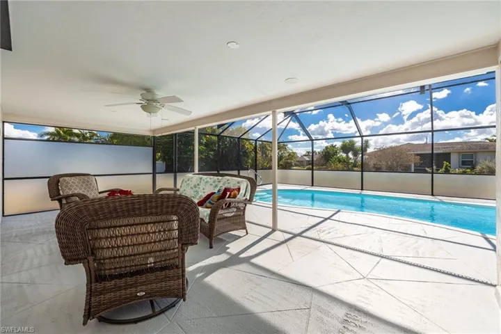 Swimming pool with a lanai, a sunroom, and a patio area