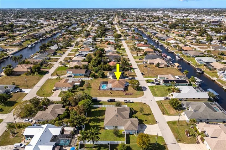 Aerial view of property and surrounding area with nearby suburban area and a large body of water
