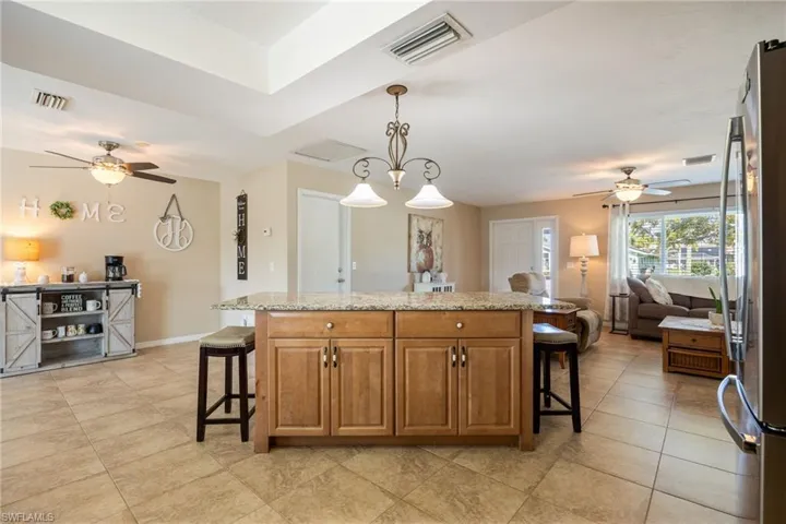 Kitchen featuring a ceiling fan, a kitchen bar, and open floor plan