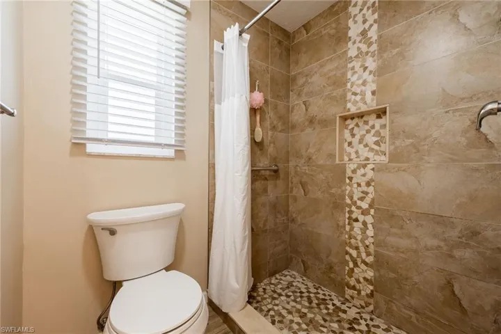 Bathroom with toilet and tiled shower