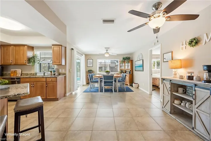 VIRTUALLY STAGED DINNING TABLE Dining space featuring healthy amount of natural light, light tile patterned floors, and ceiling fan